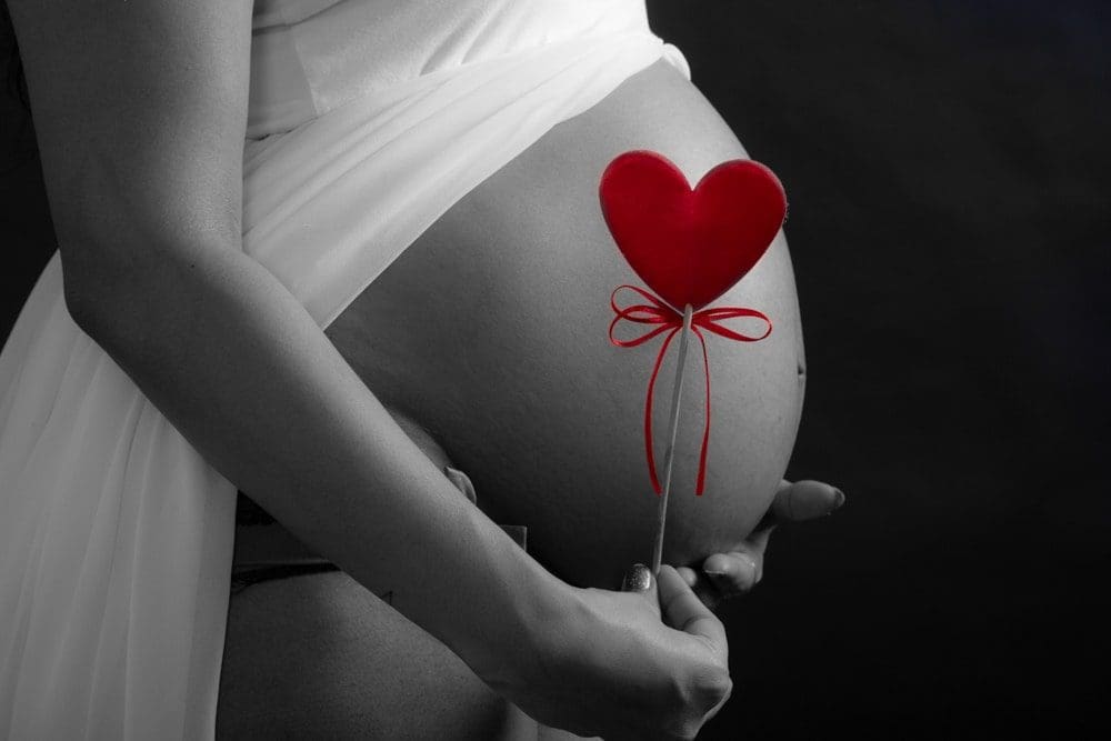 maternity photoshoot red heart next to bump