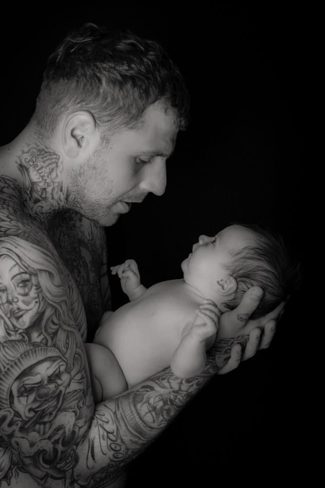 black and white newborn baby skin to skin with father in Birmingham photography studio
