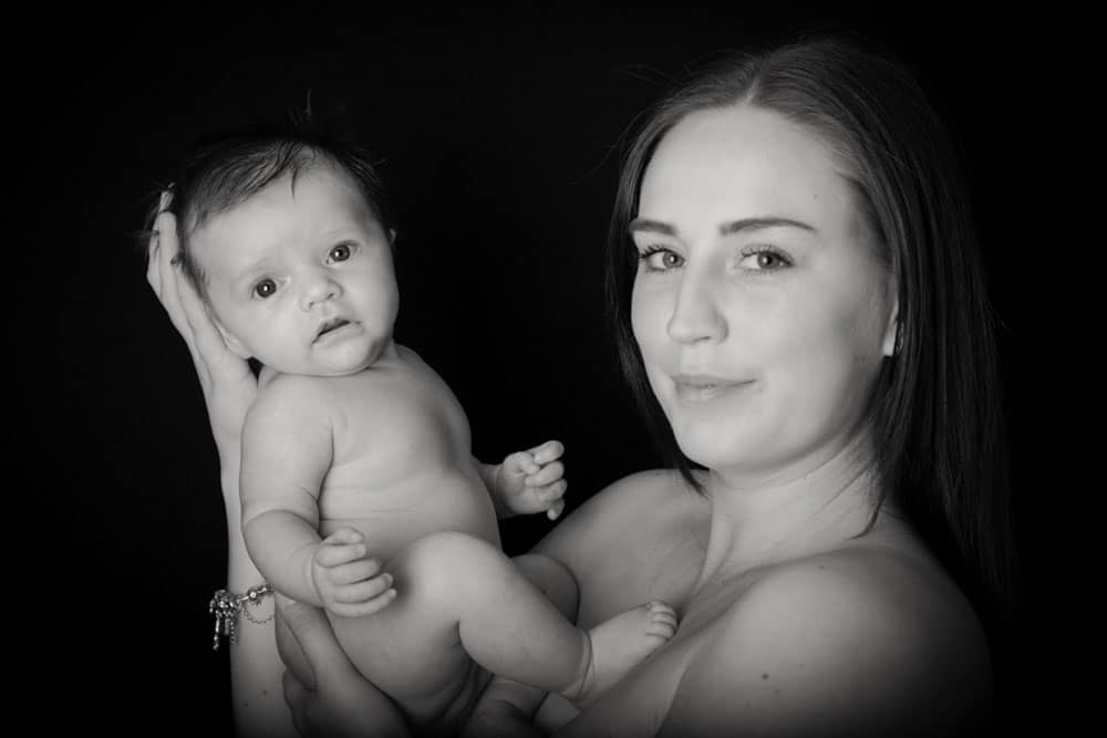 Mother gazing at newborn baby skin to skin Birmingham studio