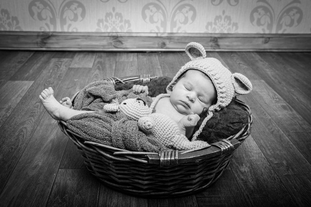 black and white newborn baby portrait in Birmingham photography studio sleeping in basket