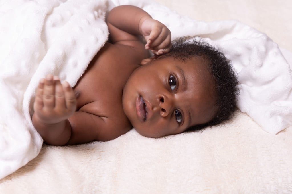 newborn baby portrait in Birmingham photography studio lying on soft white blanket