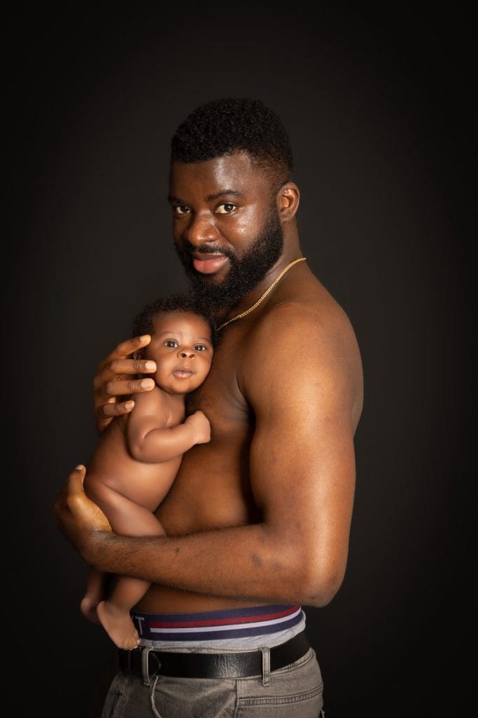 newborn baby skin to skin with father during Birmingham newborn photography studio session