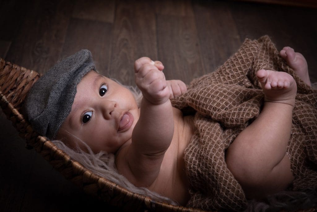 newborn baby portrait in Birmingham photography studio lying in basket with soft blanket