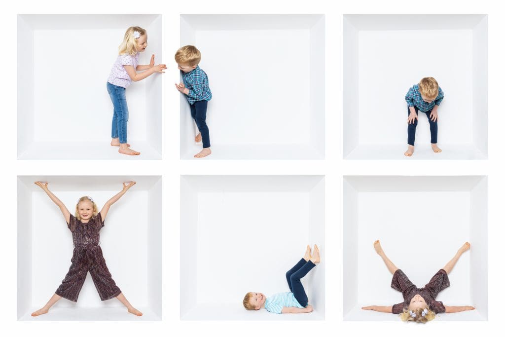 Inside the box photography of children playing and posing inside a white studio box, creating a fun and creative family portrait.