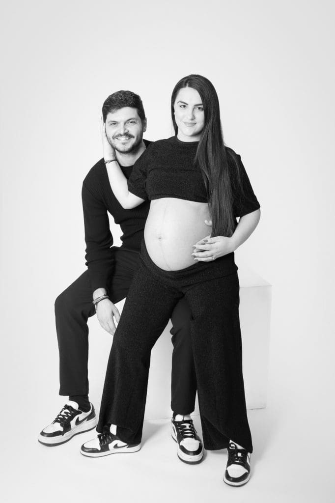Pregnant woman gently embracing her bump during a guided photoshoot