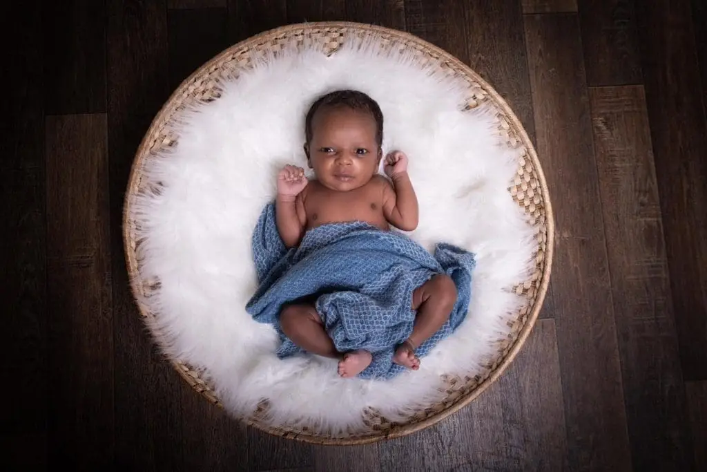 newborn baby portrait in Birmingham photography studio lying in basket with blue blanket