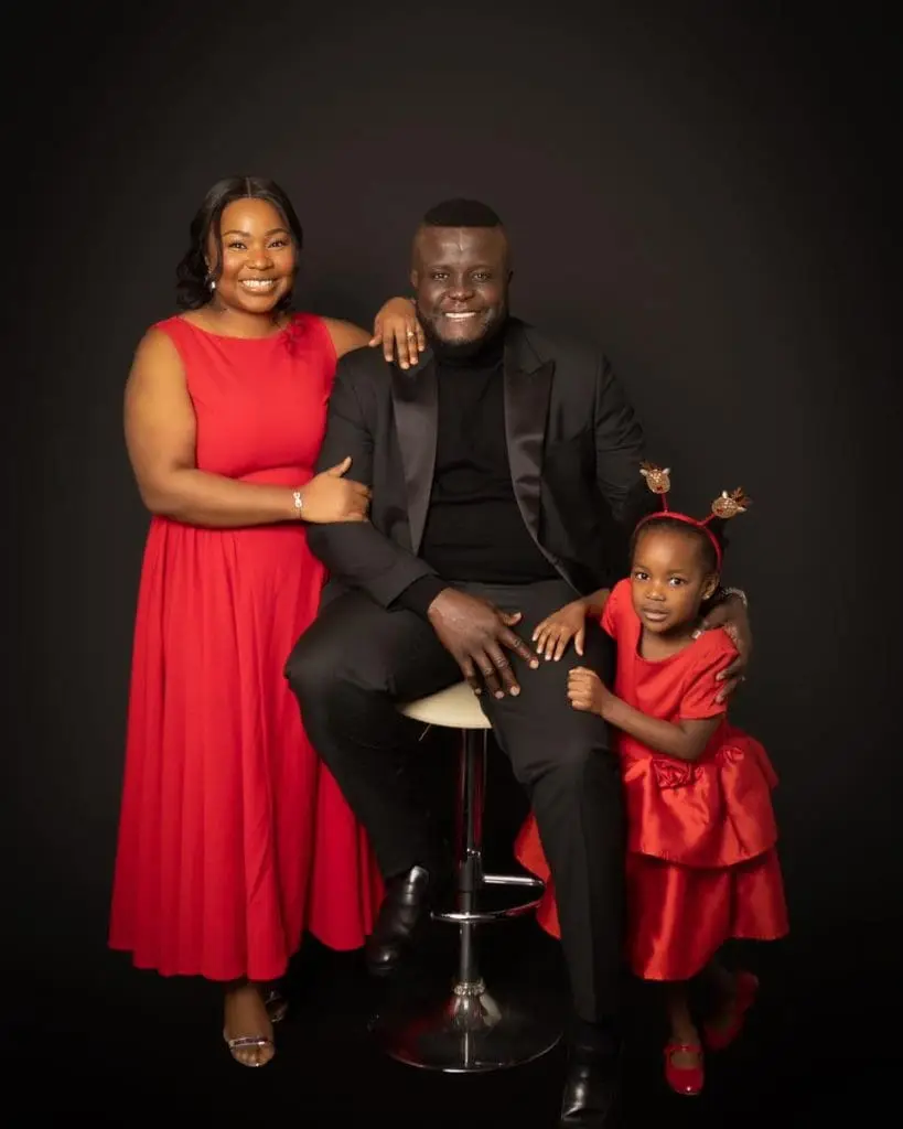 family of three studio portrait in Birmingham wearing red outfits