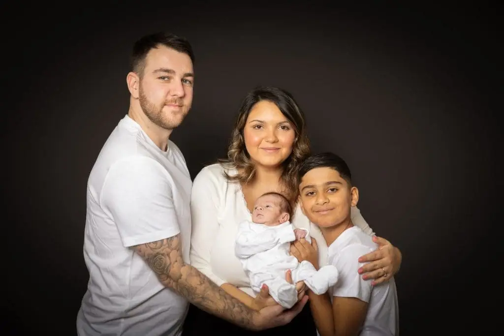 newborn baby with parents and sibling during Birmingham photography studio family session