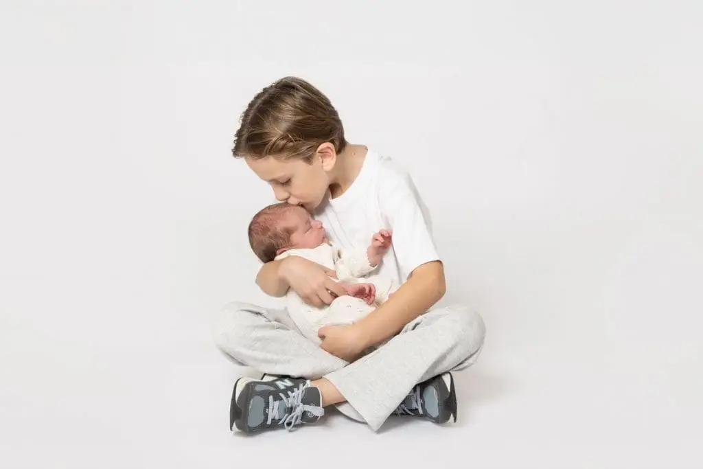 newborn baby with older sibling during Birmingham photography studio family session