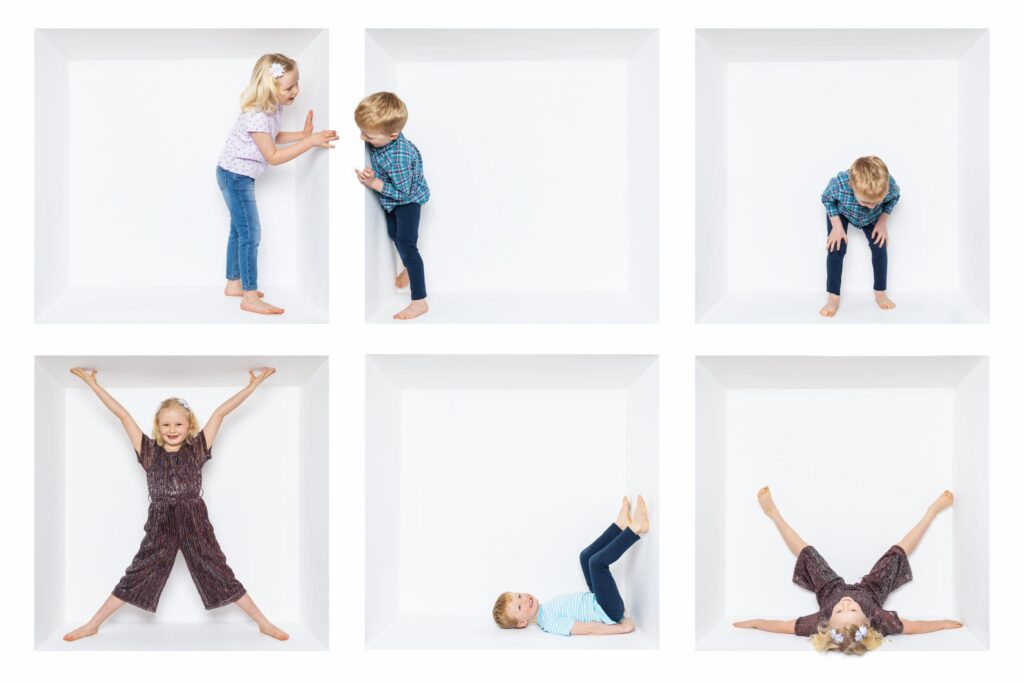 Six children pose playfully inside white square boxes, each in a different position—standing, crouching, lying down, stretching, or sitting—against a clean white background. Captured by a talented Birmingham inside the box photographer, this image showcases creativity and joyful energy in every frame.